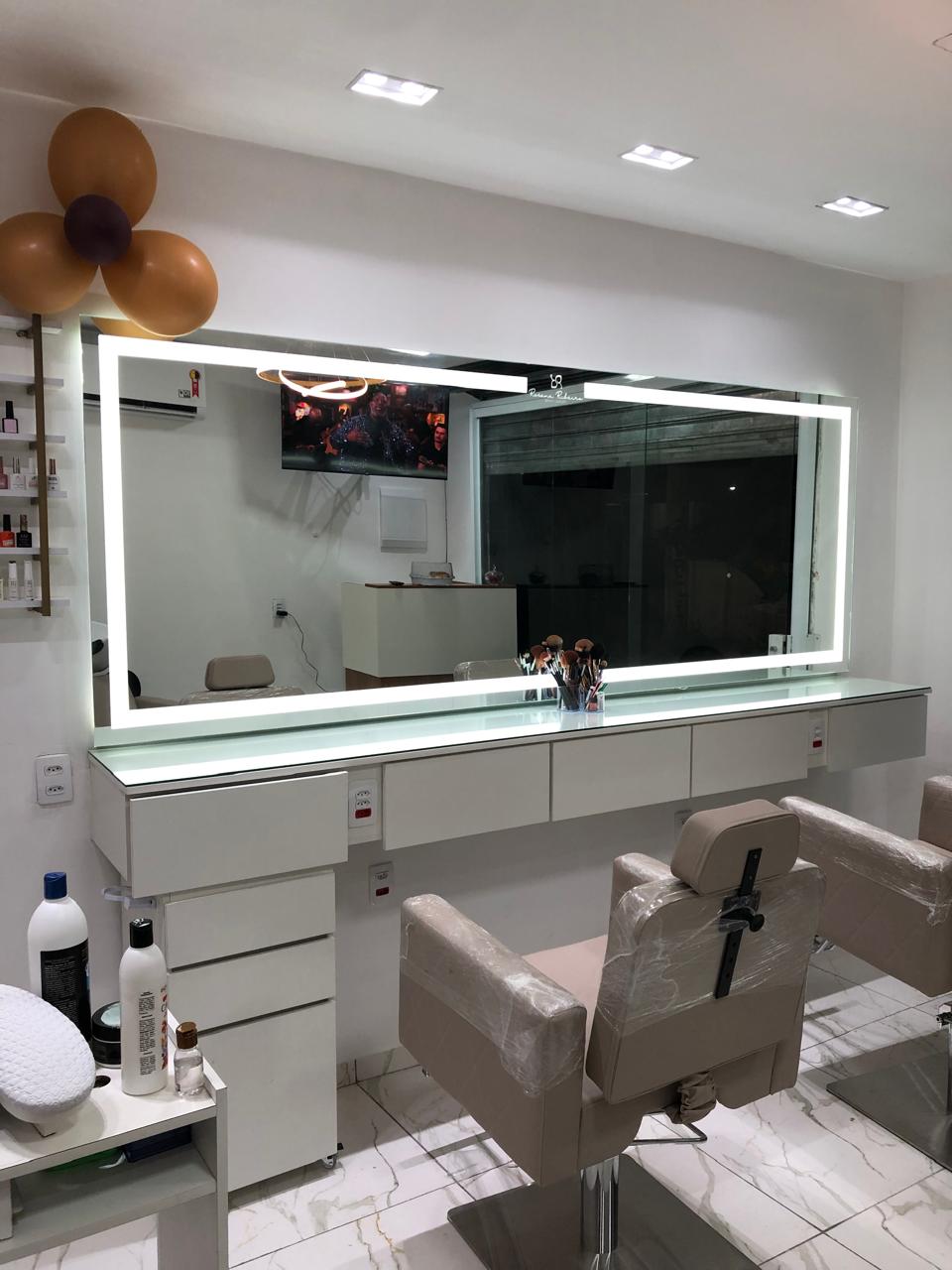 Salão de beleza com espelho LED amplo e prateleira dourada